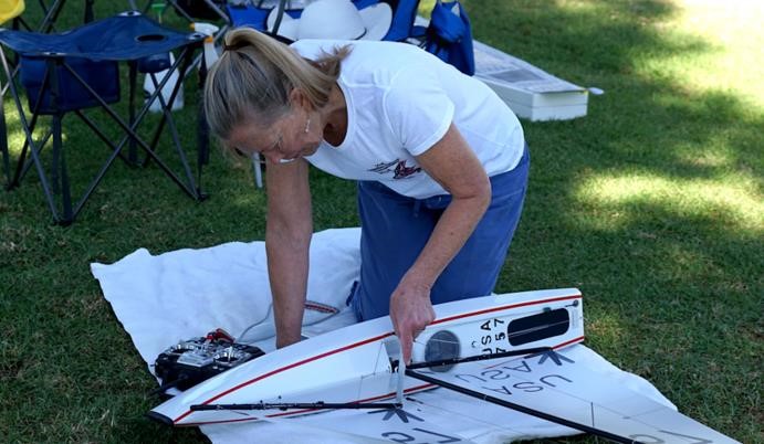 Gene Harris is shown tuning her V9 with a scale in millimeters, the class standard reference. Before she is done here the mainboom will be on or near centerline. On the last day I caught Zvonko measuring his shroud tension, as he said he had a tune he liked so he recorded it. The ability to repeat fast settings is de rigueur in this class. Robert Hirsch photo.